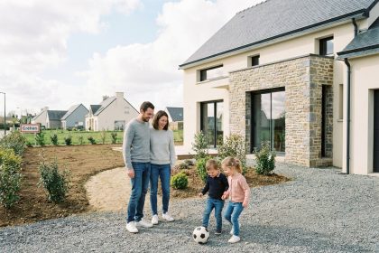 Famille heureuse devant leur maison neuve à Créhen