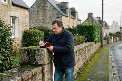 Homme d'âge moyen examine une borne frontière en pierre à SaintBrieuc